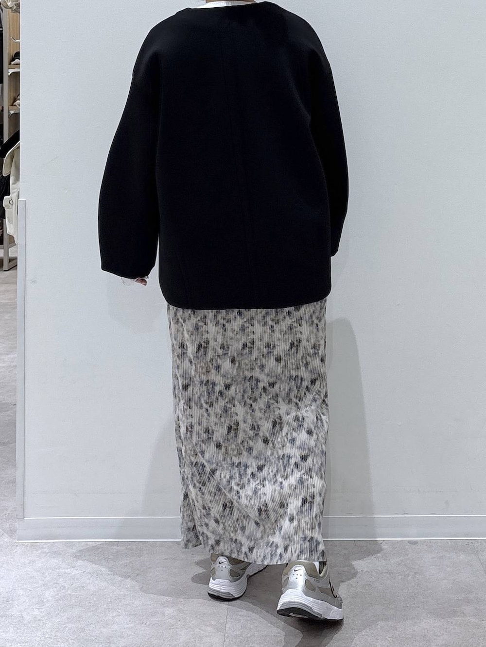 ブラック系のブルゾン、ホワイト系のTシャツ/カットソー、ベージュ系のスカートを着用したレディースの冬コーディネートの3枚目の写真