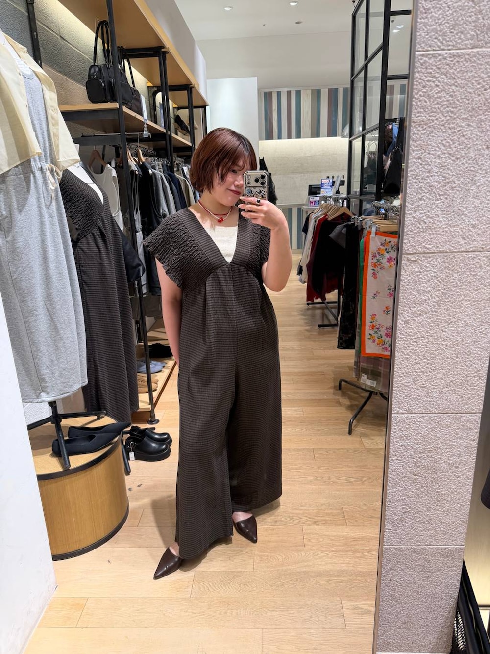 ブラウン系のサロペット/オーバーオール、ゴールド系のタンクトップ、ブラウン系のサンダルを着用したレディースの春コーディネートの5枚目の写真