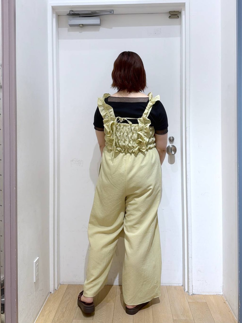 ブラウン系のサンダル、ホワイト系のショルダーバッグ、ブラック系のTシャツ/カットソーを着用したレディースの春コーディネートの4枚目の写真