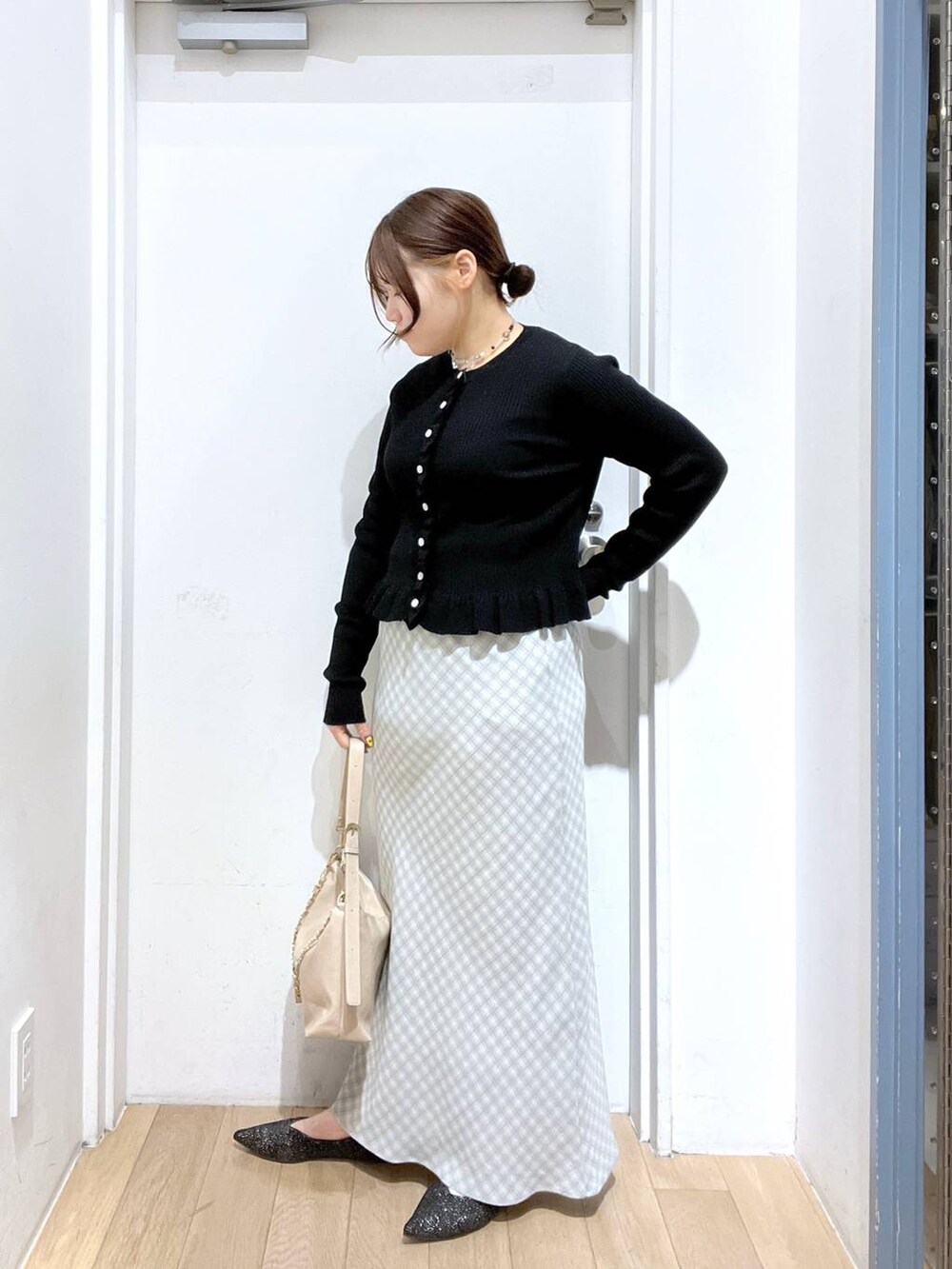 ベージュ系のショルダーバッグ、ブラック系のパンプス、ブラック系のTシャツ/カットソーを着用したレディースの冬コーディネートの3枚目の写真