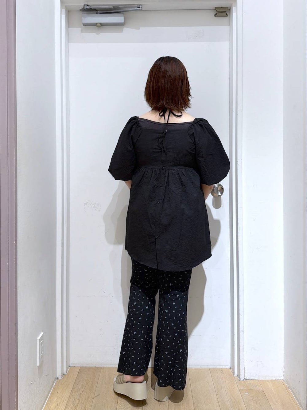 ホワイト系のサンダル、ブラック系のその他パンツ、ブラック系のシャツ/ブラウスを着用したレディースの夏コーディネートの3枚目の写真