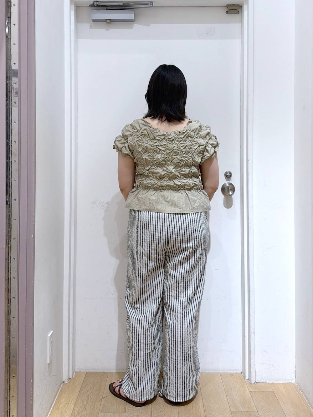 ベージュ系のシャツ/ブラウス、シルバー系のタンクトップ、ブラウン系のサンダルを着用したレディースの夏コーディネートの4枚目の写真