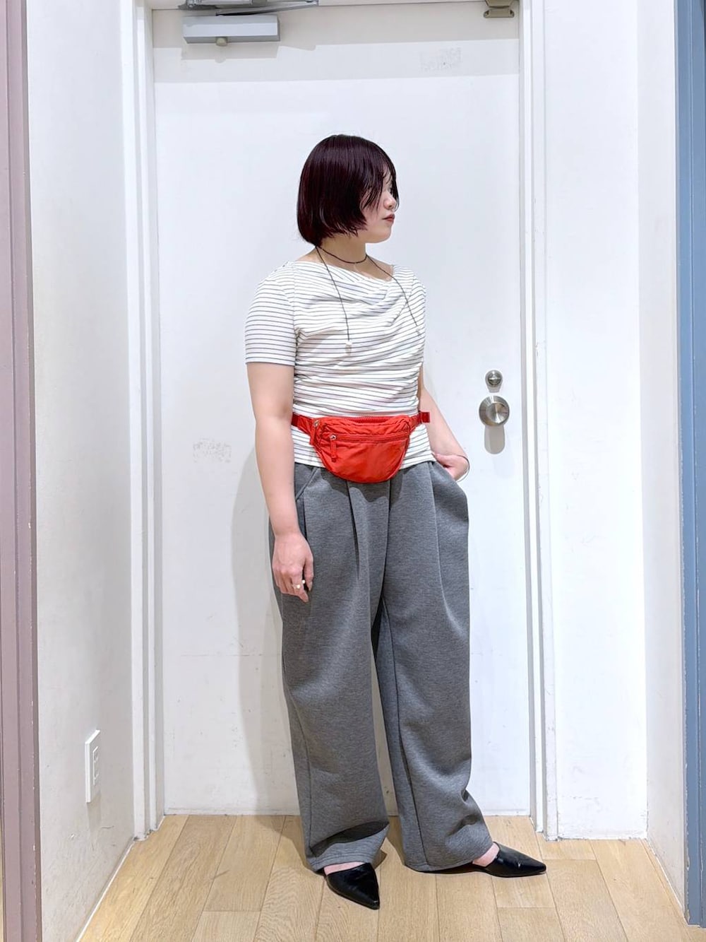 グレー系のスウェットパンツ、レッド系のボディバッグ/ウエストポーチ、ホワイト系のTシャツ/カットソーを着用したレディースの春コーディネートの3枚目の写真
