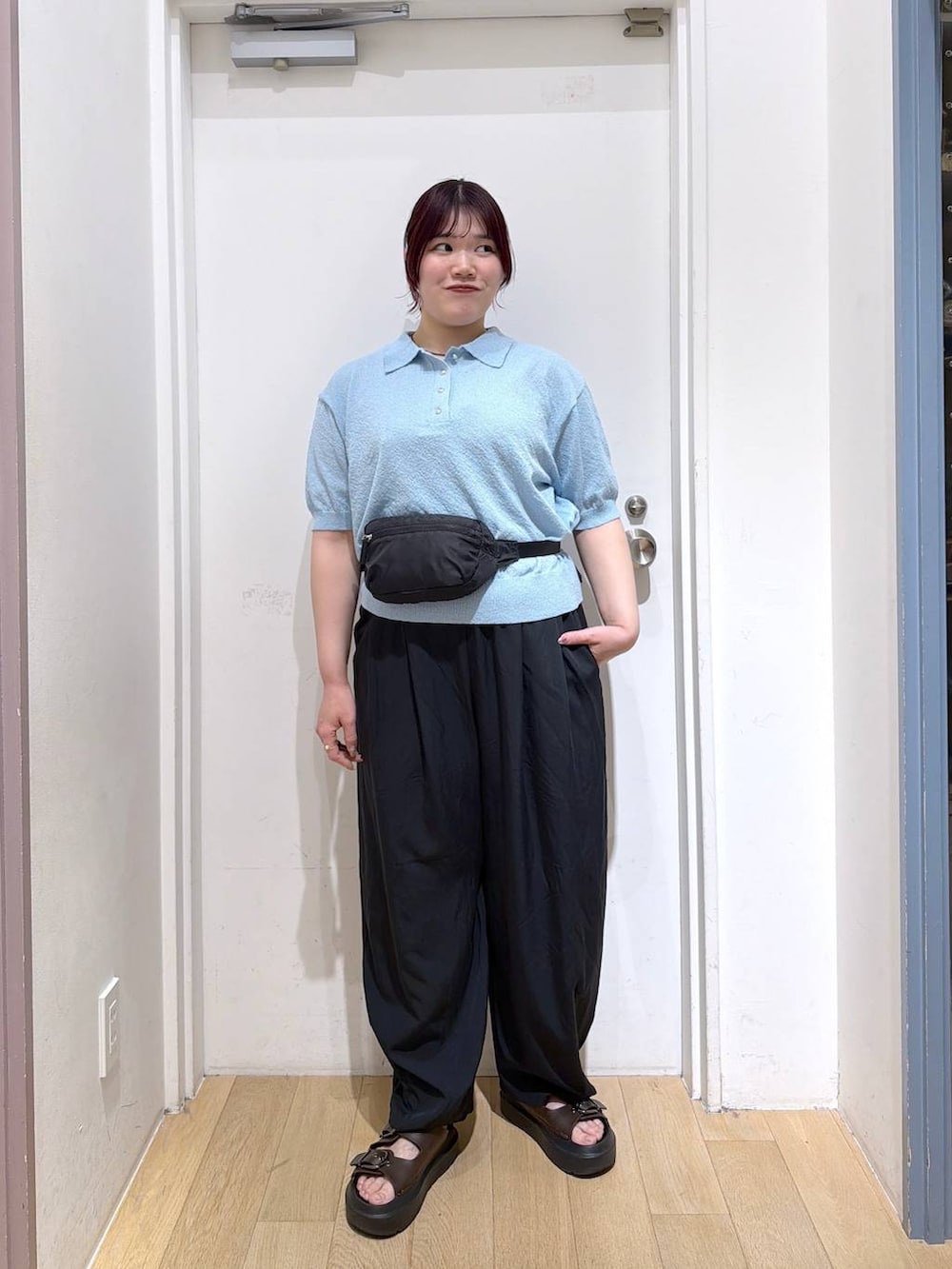 ブラック系のボディバッグ/ウエストポーチ、ブラック系のその他パンツ、ブルー系のTシャツ/カットソーを着用したレディースの春コーディネートの2枚目の写真