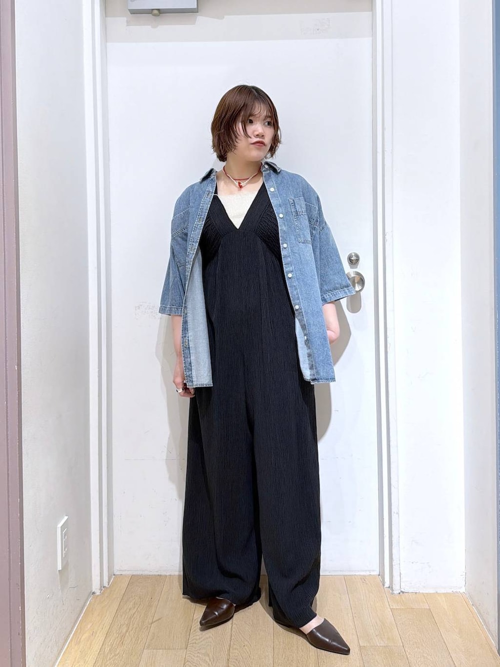 ブラック系のサロペット/オーバーオール、ゴールド系のタンクトップ、ブルー系のシャツ/ブラウスを着用したレディースの春コーディネートの2枚目の写真