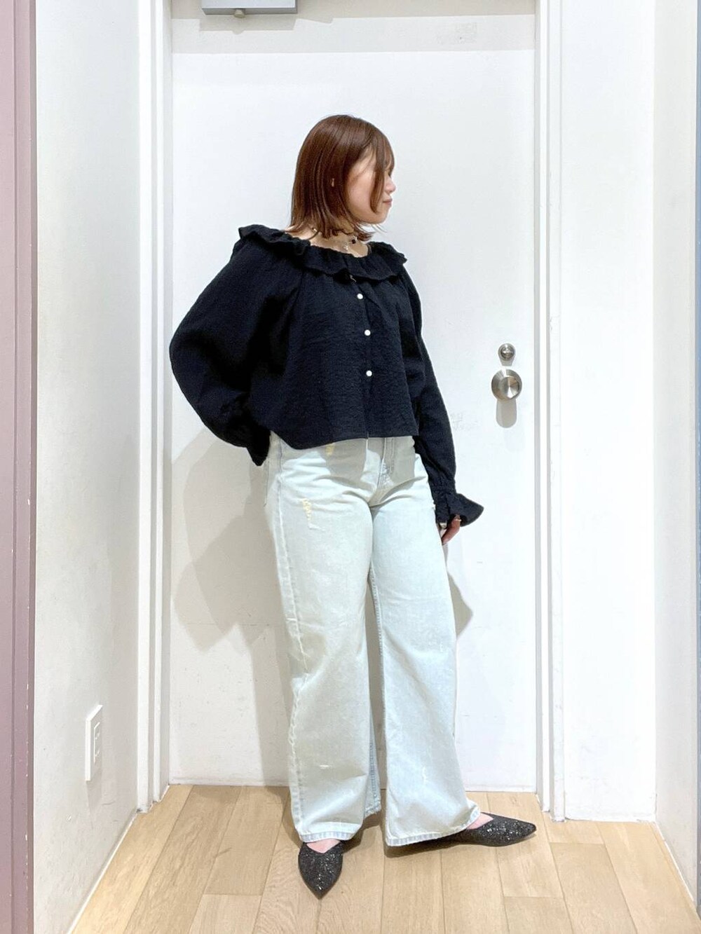 ブルー系のデニムパンツ、ブラック系のパンプス、ブラック系のシャツ/ブラウスを着用したレディースの冬コーディネートの2枚目の写真