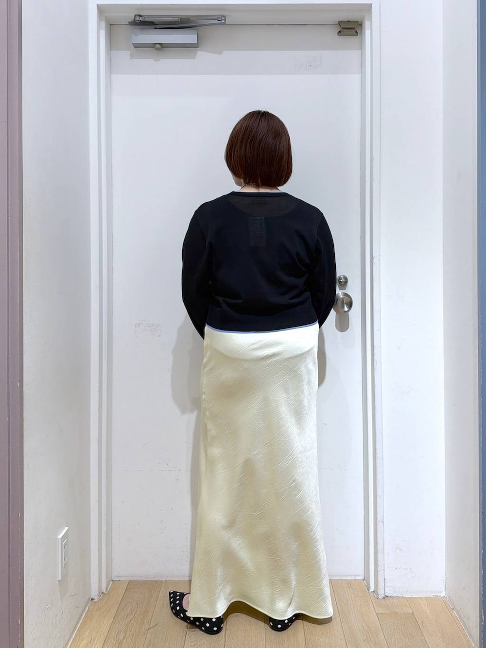 イエロー系のスカート、その他のパンプス、ブラック系のカーディガン/ボレロを着用したレディースの春コーディネートの4枚目の写真