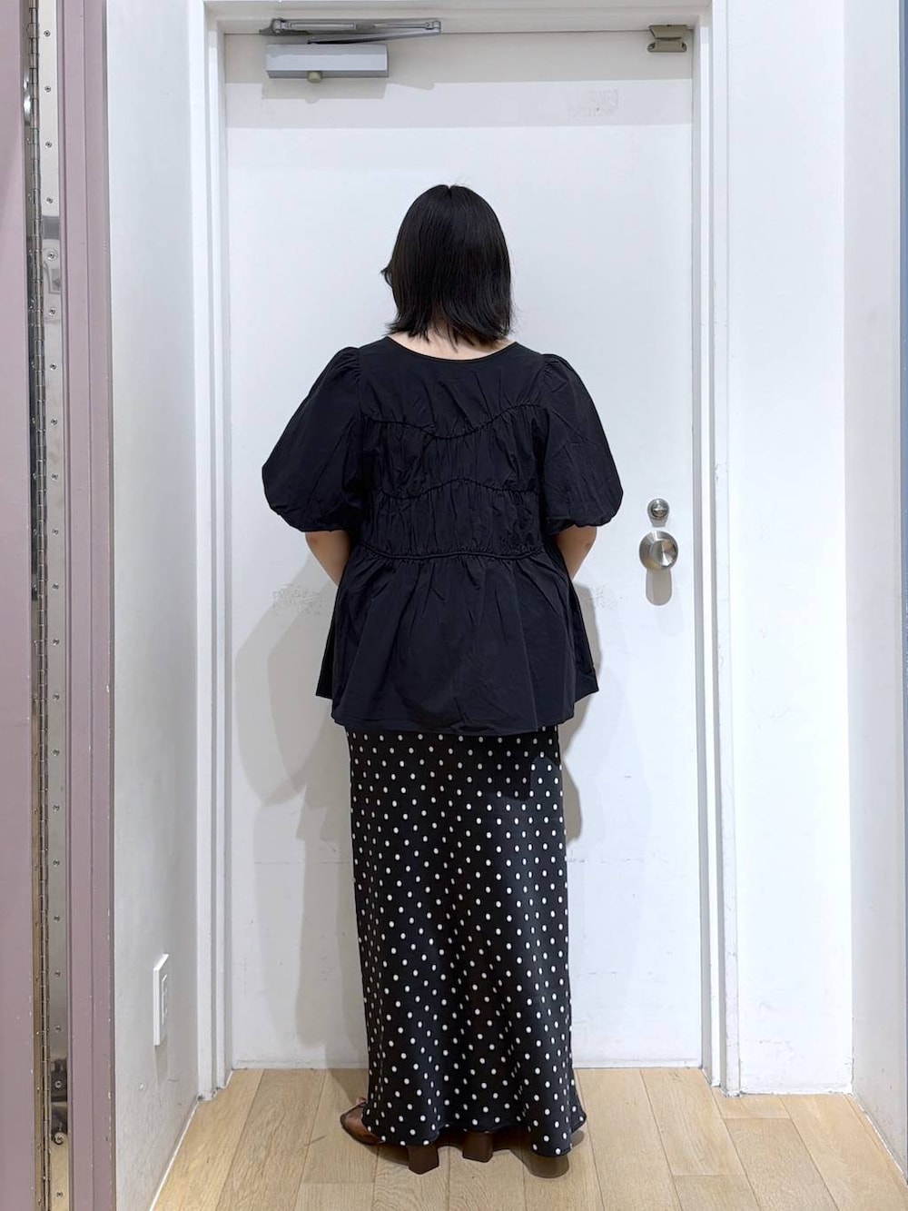 ブラック系のシャツ/ブラウス、ブラック系のスカート、ブラウン系のサンダルを着用したレディースの夏コーディネートの4枚目の写真