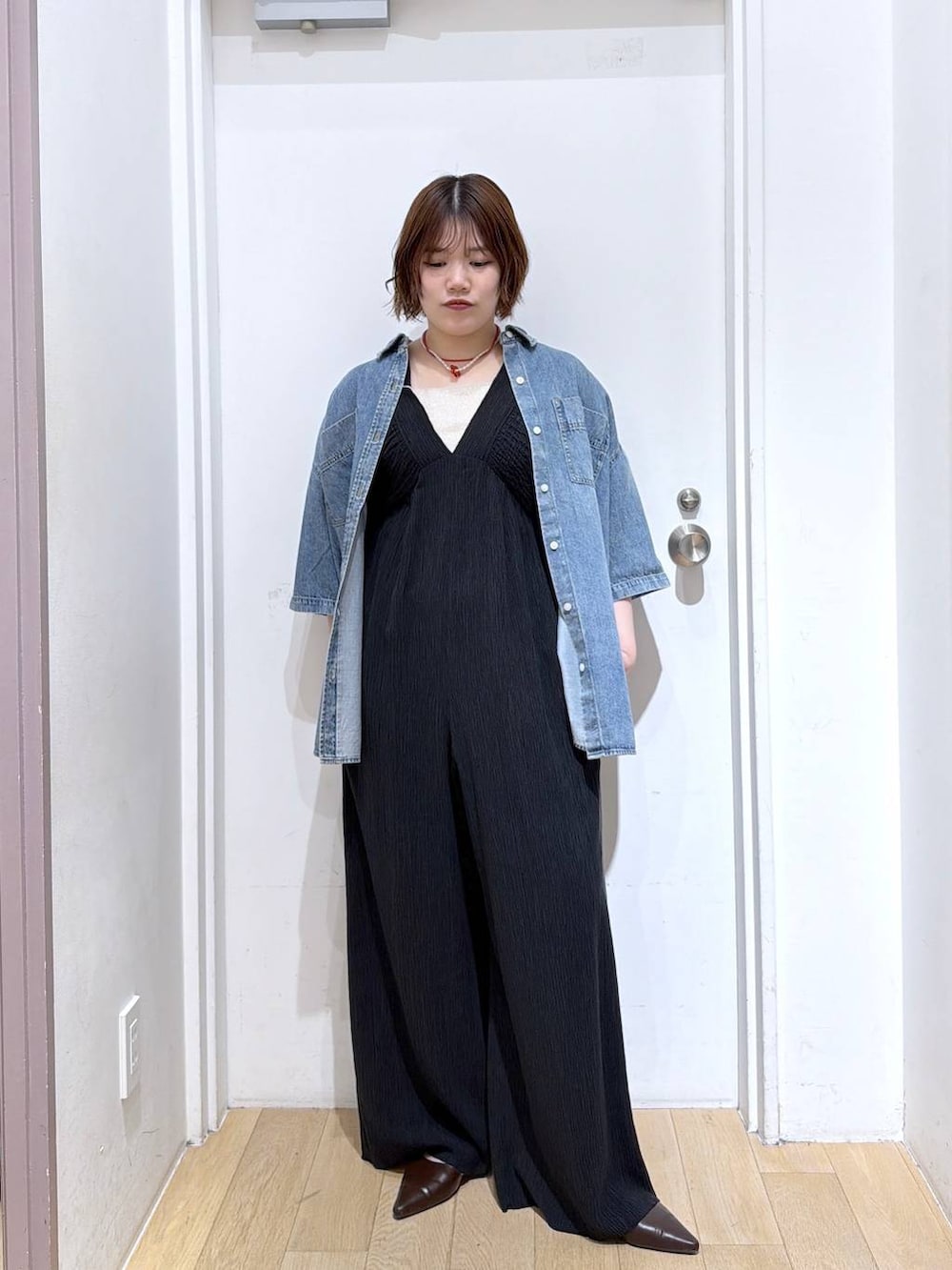 ブラック系のサロペット/オーバーオール、ゴールド系のタンクトップ、ブルー系のシャツ/ブラウスを着用したレディースの春コーディネートの3枚目の写真