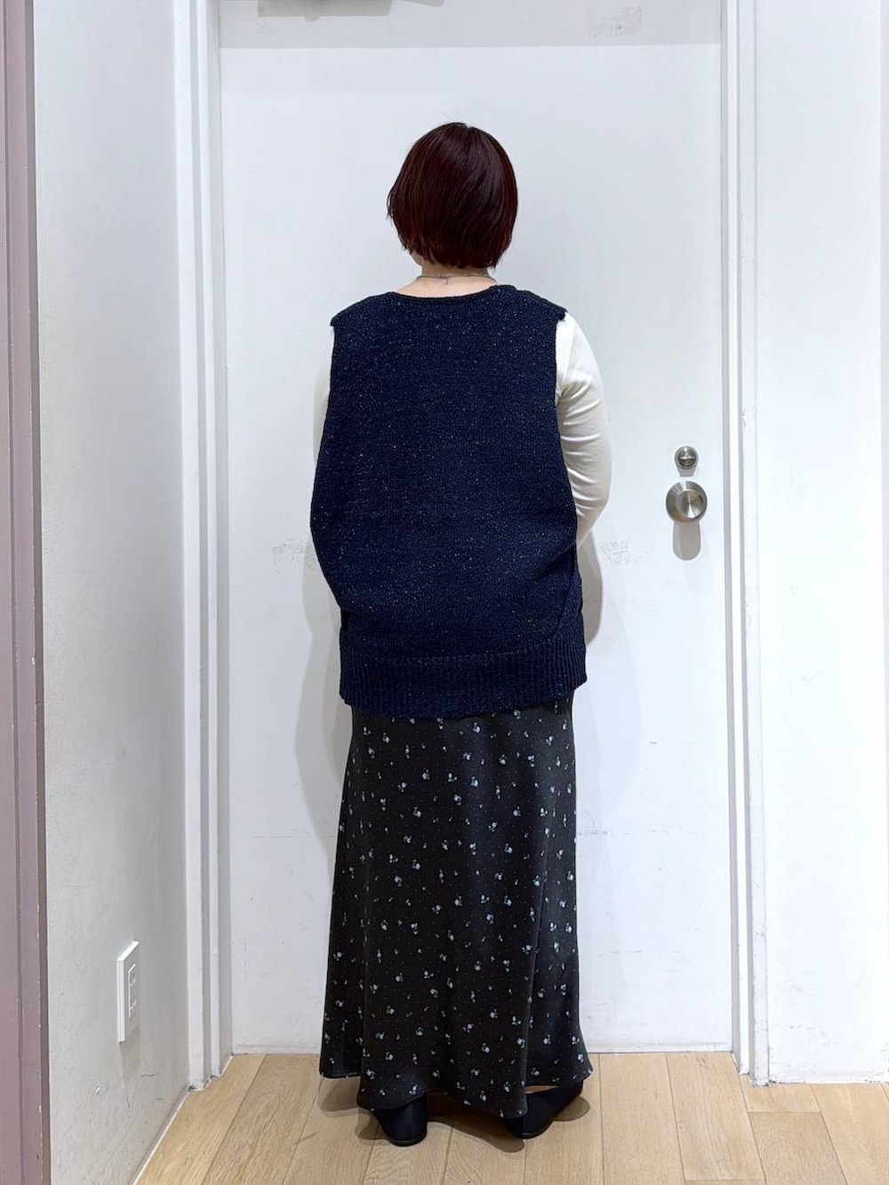 ブラック系のスカート、ブラック系のパンプス、ホワイト系のTシャツ/カットソーを着用したレディースの春コーディネートの4枚目の写真