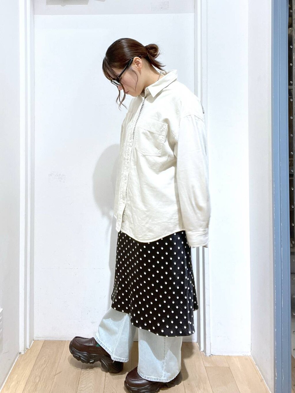 ブラック系のスカート、ベージュ系のシャツ/ブラウス、ブルー系のデニムパンツを着用したレディースの冬コーディネートの2枚目の写真