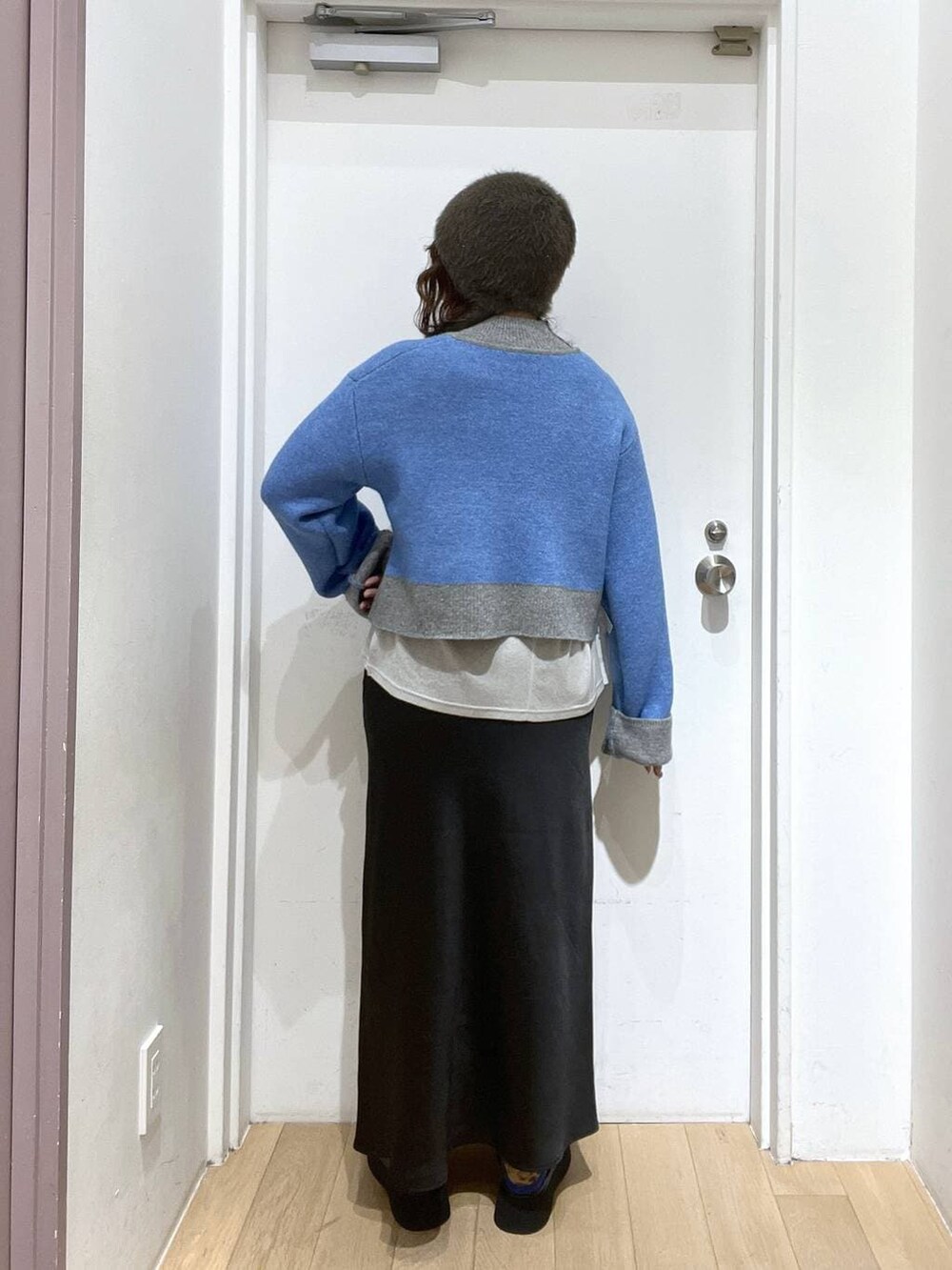 ブラック系のスカート、ブラウン系のサンダル、グレー系のニット/セーターを着用したレディースの冬コーディネートの3枚目の写真