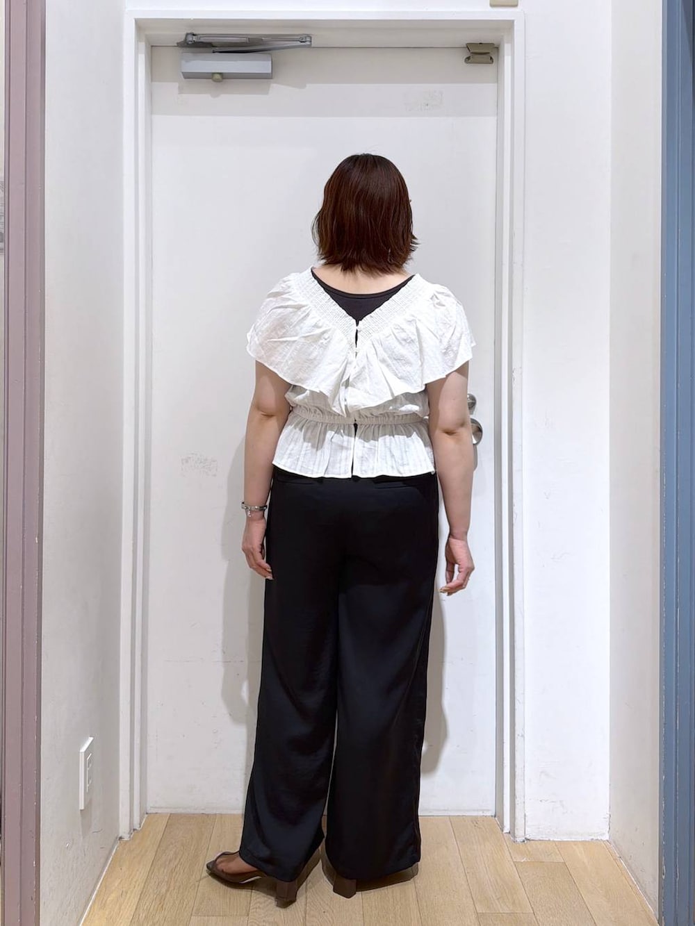 ブラック系のその他パンツ、ブラウン系のサンダル、ホワイト系のシャツ/ブラウスを着用したレディースの夏コーディネートの4枚目の写真