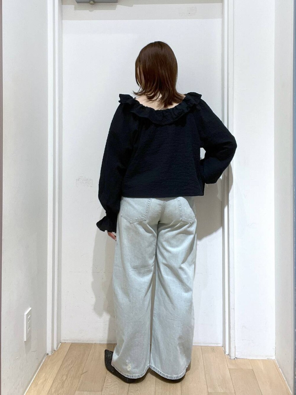 ブルー系のデニムパンツ、ブラック系のパンプス、ブラック系のシャツ/ブラウスを着用したレディースの冬コーディネートの3枚目の写真