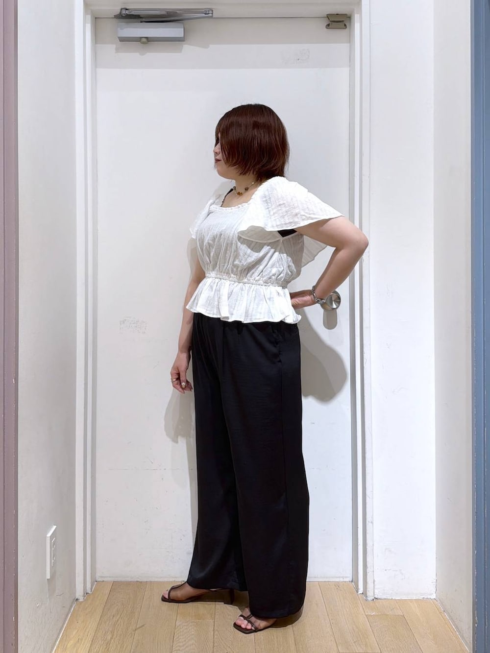 ブラック系のその他パンツ、ブラウン系のサンダル、ホワイト系のシャツ/ブラウスを着用したレディースの夏コーディネートの3枚目の写真