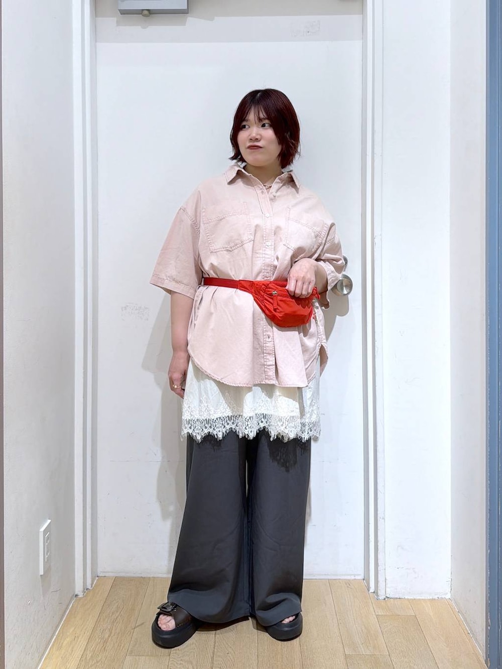 グレー系のその他パンツ、レッド系のボディバッグ/ウエストポーチ、ピンク系のシャツ/ブラウスを着用したレディースの春コーディネートの2枚目の写真