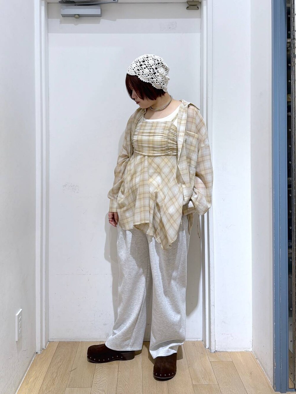 グレー系のスウェットパンツ、ブラウン系のサンダル、ホワイト系のタンクトップを着用したレディースの春コーディネートの3枚目の写真