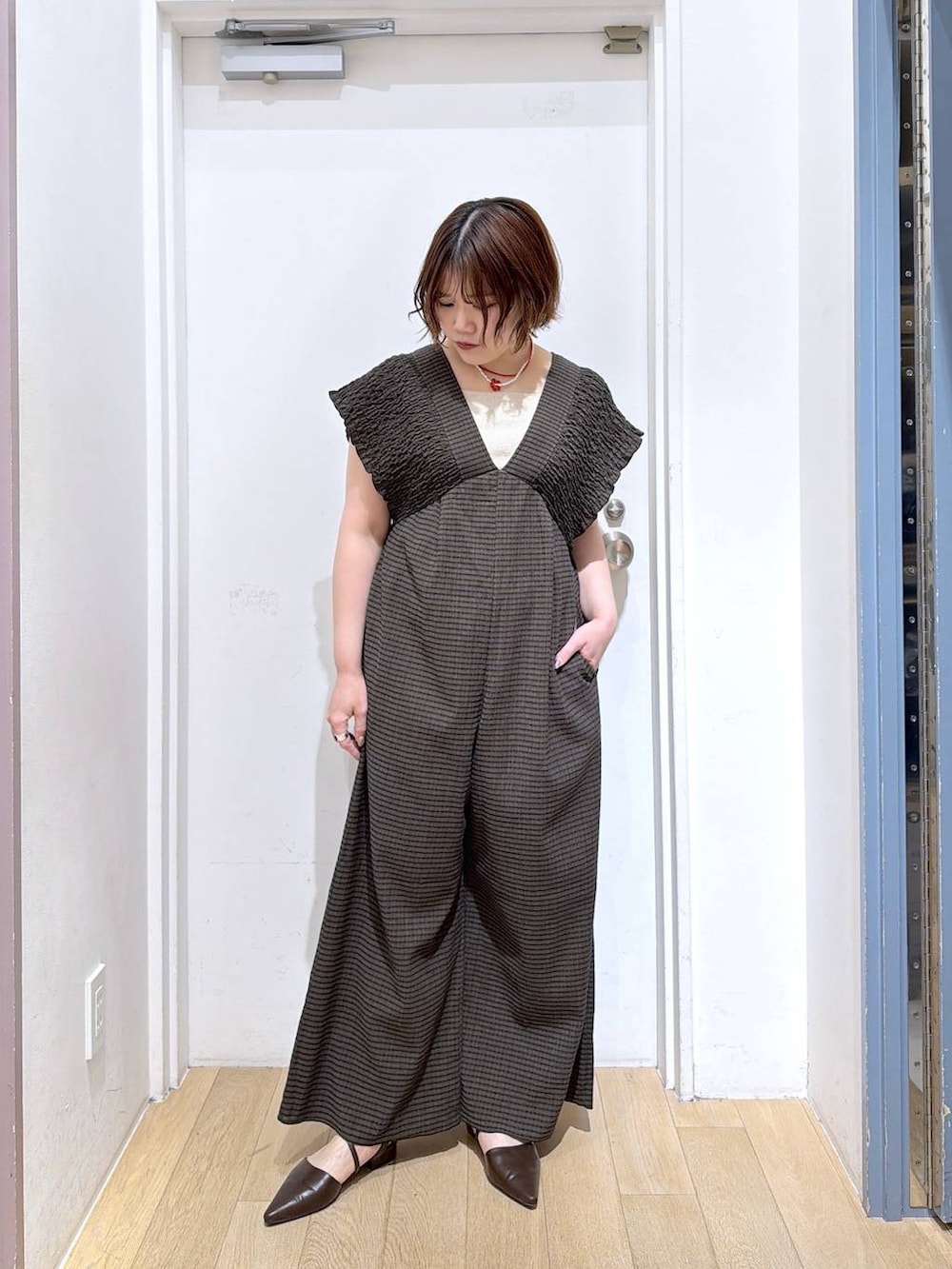 ブラウン系のサロペット/オーバーオール、ゴールド系のタンクトップ、ブラウン系のサンダルを着用したレディースの春コーディネートの2枚目の写真