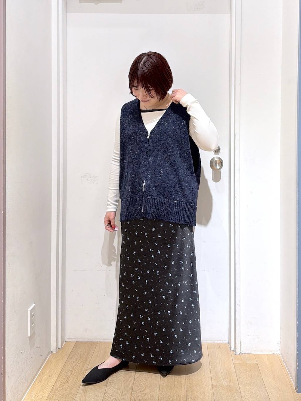 ブラック系のスカート、ブラック系のパンプス、ホワイト系のTシャツ/カットソーを着用したレディースの春コーディネートの2枚目の写真