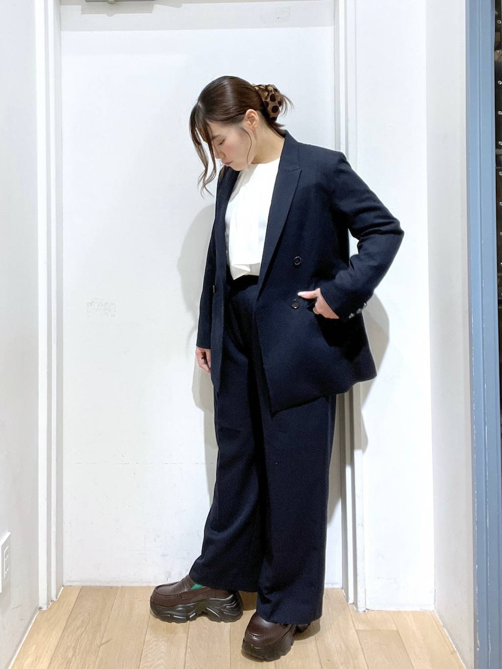 ブルー系のテーラードジャケット、ブルー系のスラックス、ホワイト系のシャツ/ブラウスを着用したレディースの冬コーディネートの2枚目の写真