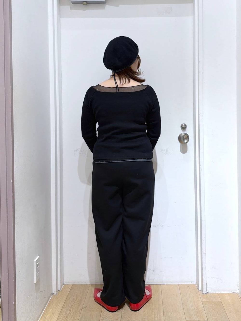 ブラック系のスウェットパンツ、レッド系のパンプス、ブラック系のTシャツ/カットソーを着用したレディースの冬コーディネートの3枚目の写真