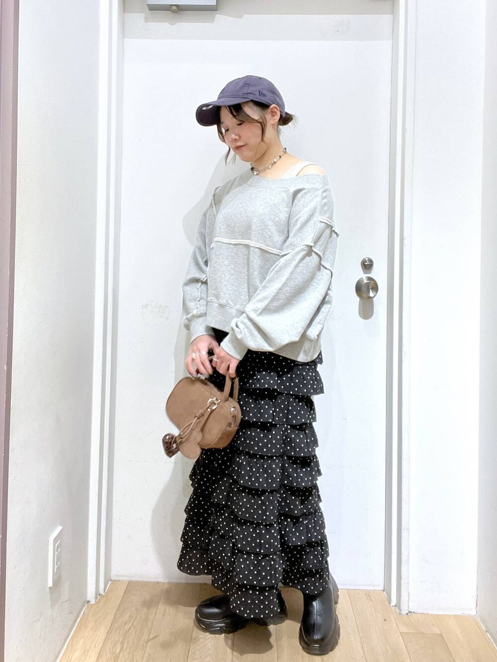 ブラック系のブーツ、グレー系のスウェット、ブラウン系のボストンバッグを着用したレディースの秋コーディネートの2枚目の写真