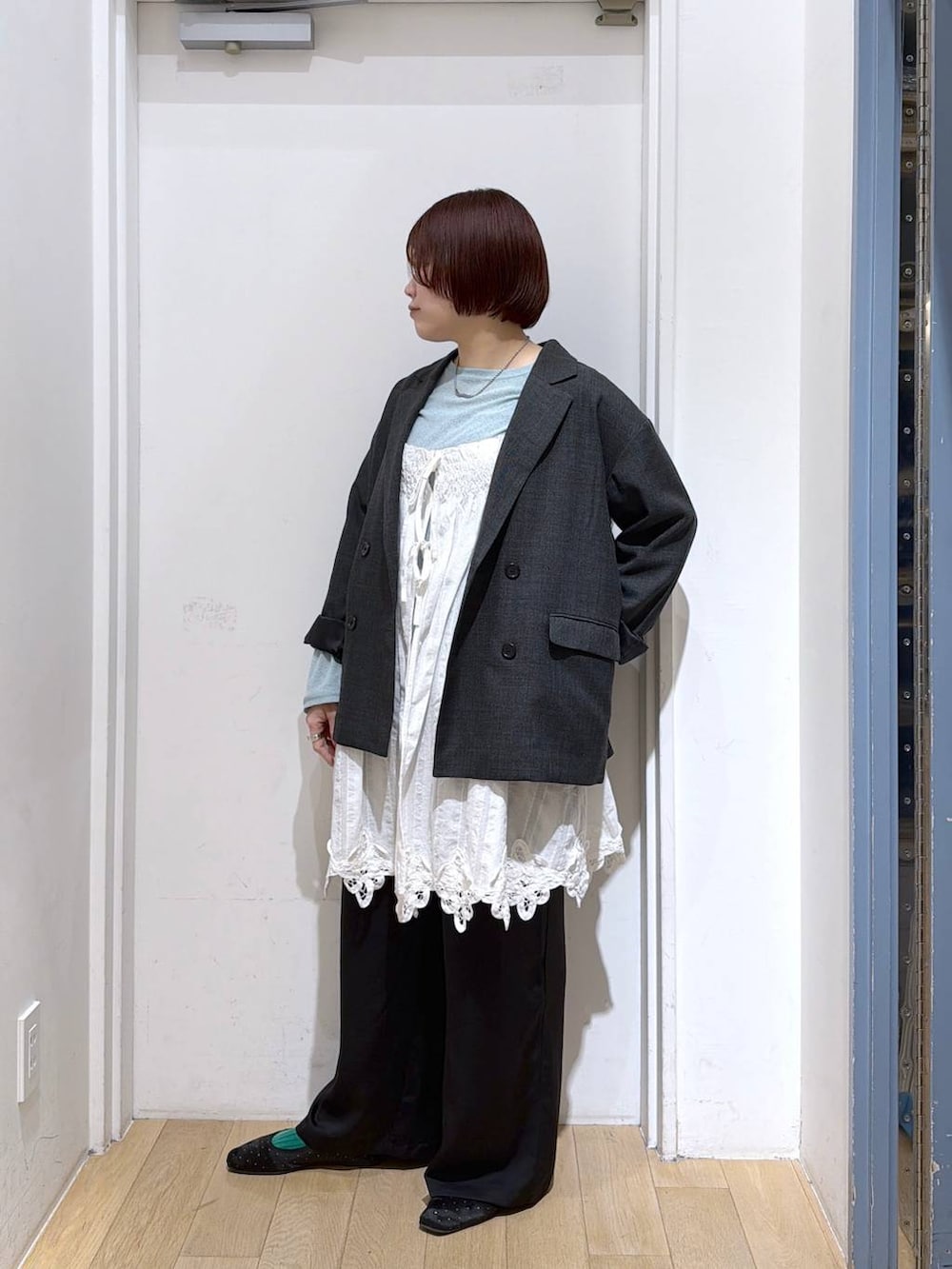 グレー系のテーラードジャケット、ブラック系のその他パンツ、ホワイト系のワンピースを着用したレディースの春コーディネートの2枚目の写真