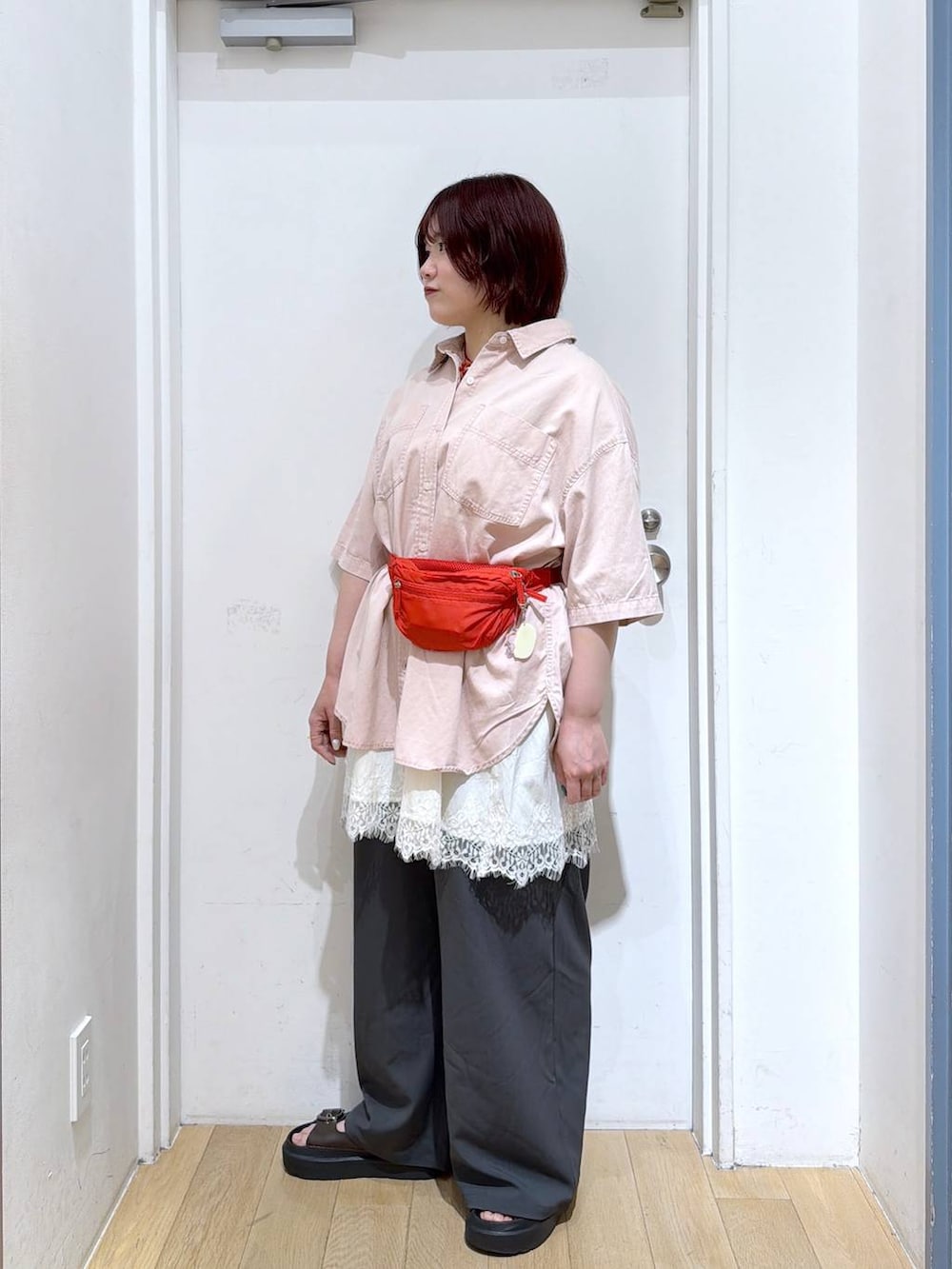 グレー系のその他パンツ、レッド系のボディバッグ/ウエストポーチ、ピンク系のシャツ/ブラウスを着用したレディースの春コーディネートの3枚目の写真