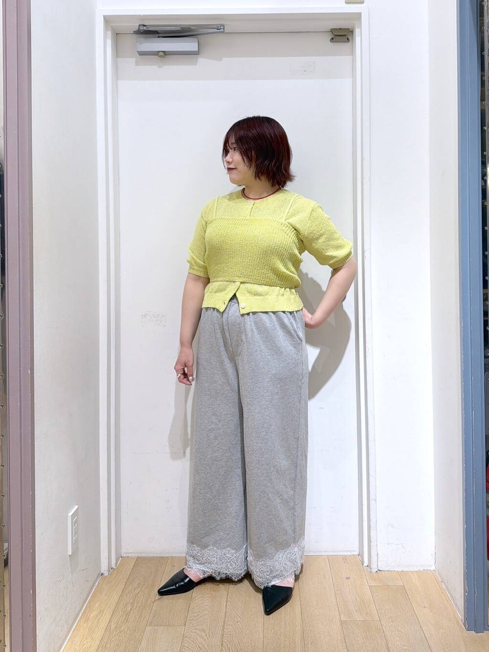 ブラック系のサンダル、グレー系のスウェットパンツ、イエロー系のTシャツ/カットソーを着用したレディースの春コーディネートの3枚目の写真