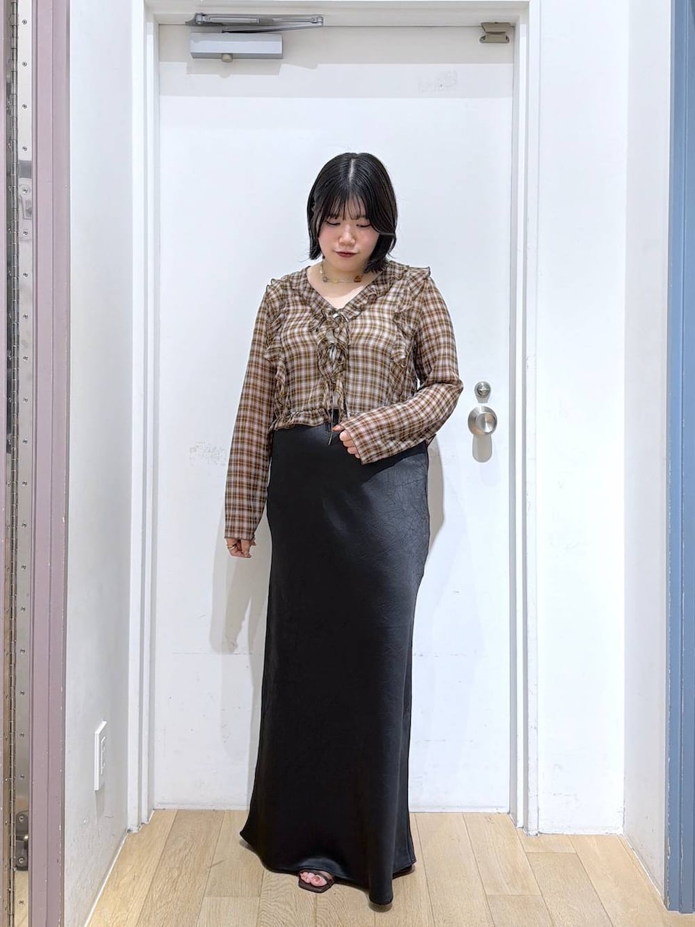 ブラウン系のシャツ/ブラウス、ブラック系のスカート、シルバー系のタンクトップを着用したレディースの夏コーディネートの5枚目の写真