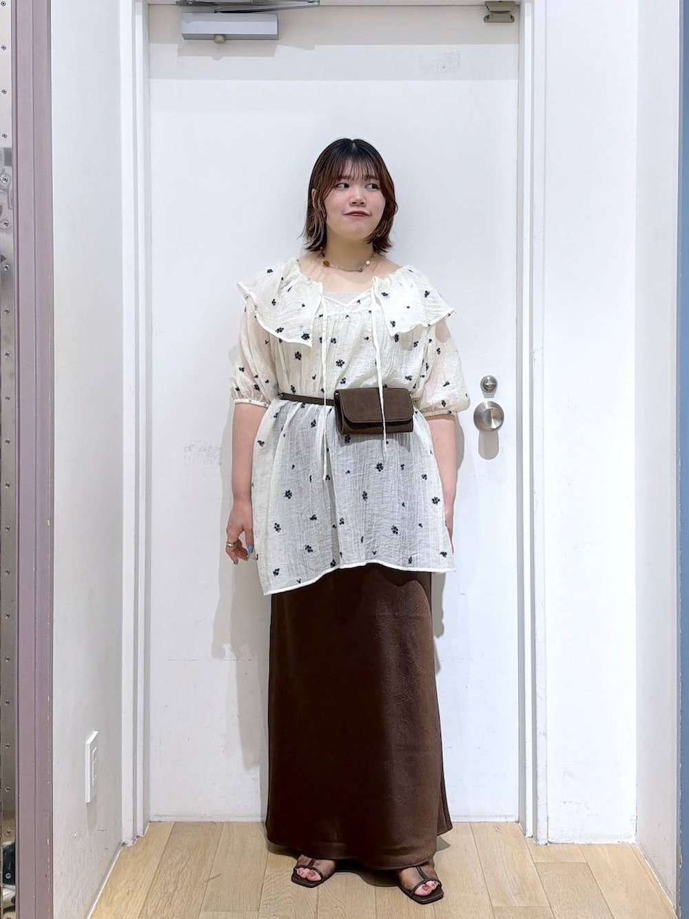 ホワイト系のワンピース、ブラウン系のスカート、シルバー系のタンクトップを着用したレディースの夏コーディネートの2枚目の写真