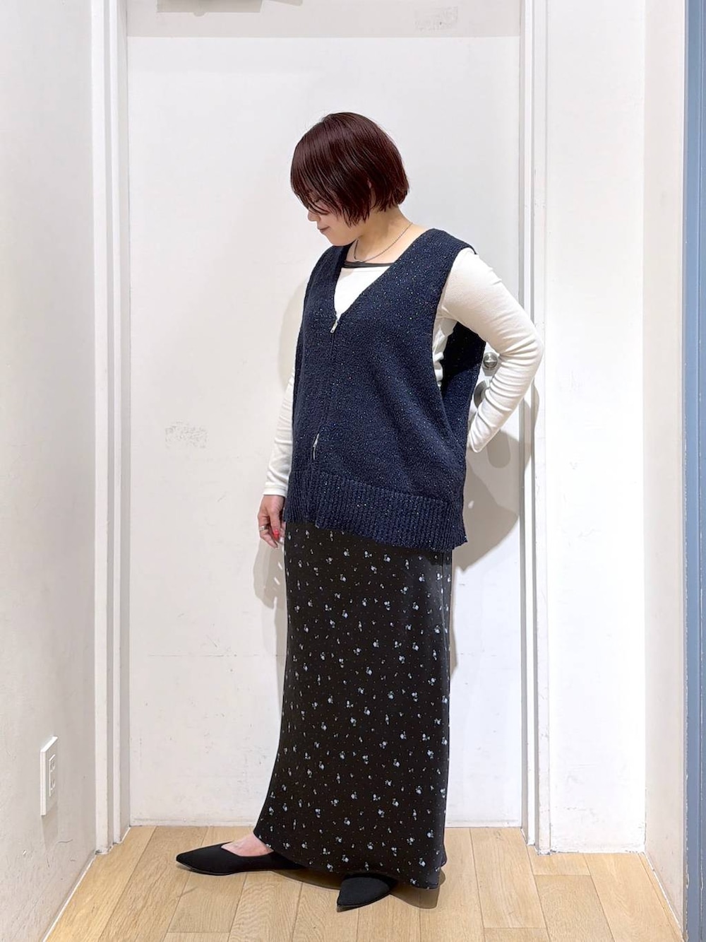 ブラック系のスカート、ブラック系のパンプス、ホワイト系のTシャツ/カットソーを着用したレディースの春コーディネートの3枚目の写真