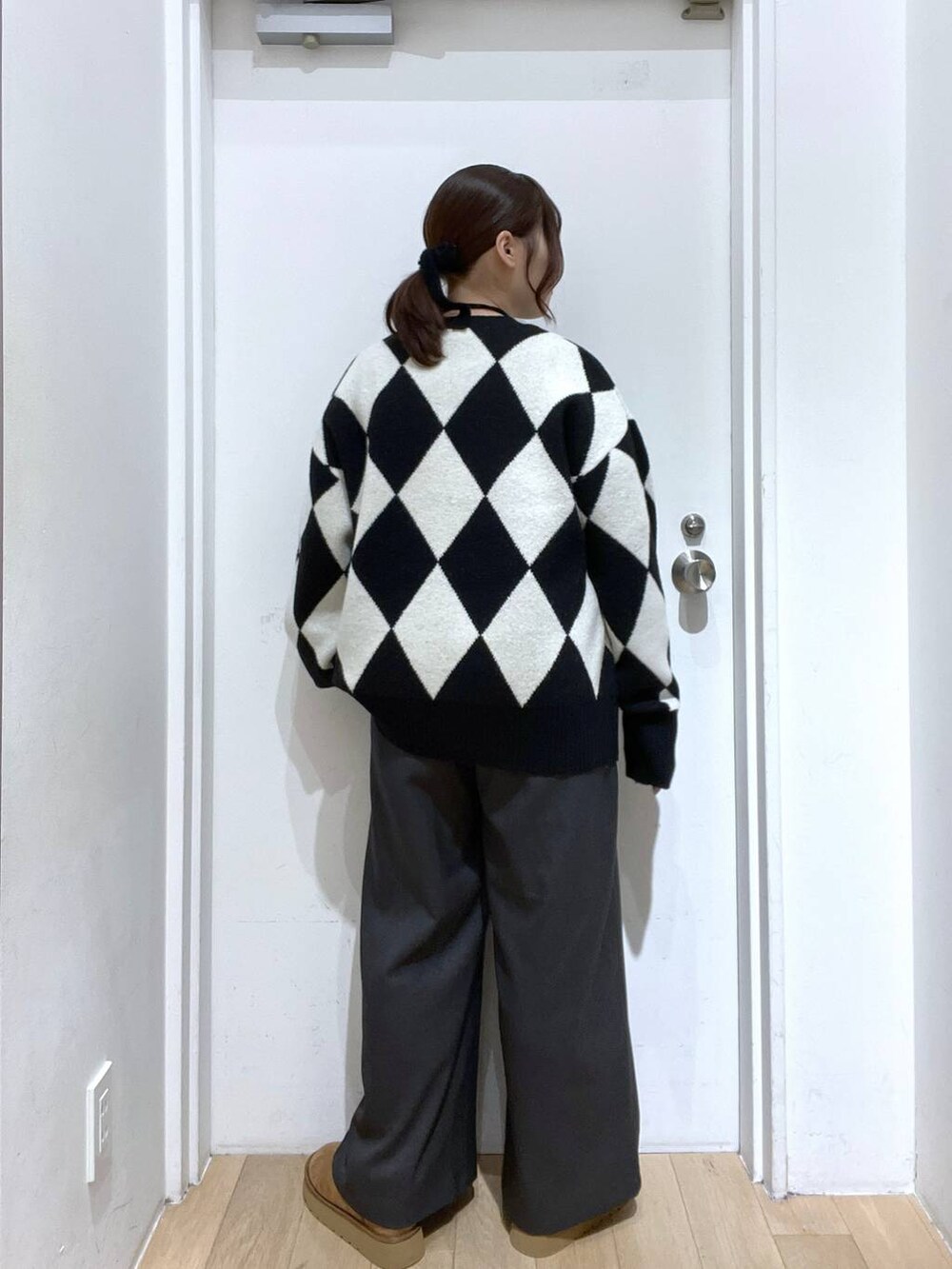 グレー系のその他パンツ、ブラック系のニット/セーター、ベージュ系のブーツを着用したレディースの秋コーディネートの3枚目の写真