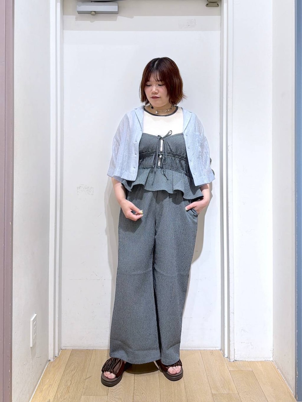 ピンク系のタンクトップ、ブラウン系のサンダル、ブルー系のシャツ/ブラウスを着用したレディースの春コーディネートの2枚目の写真