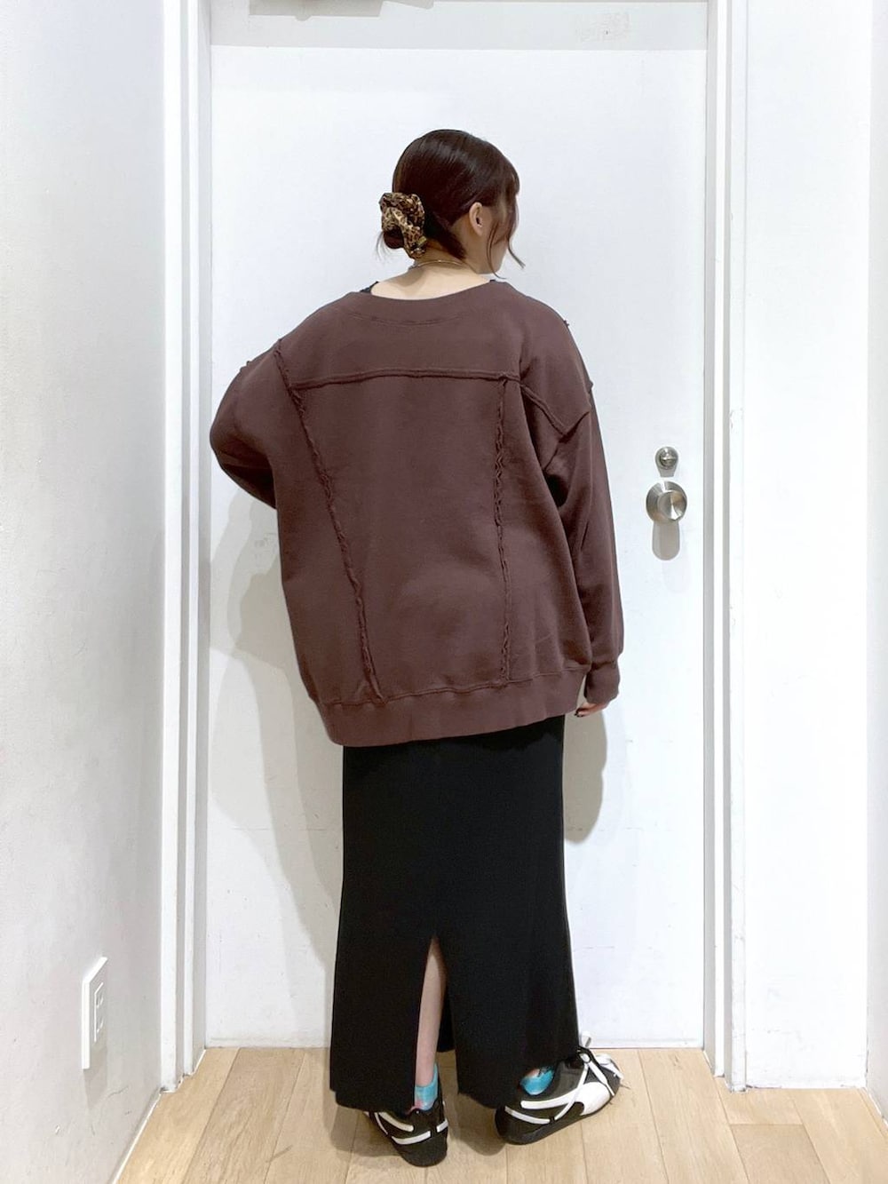 ブラック系のスカート、ブラウン系のスウェットを着用したレディースの秋コーディネートの3枚目の写真