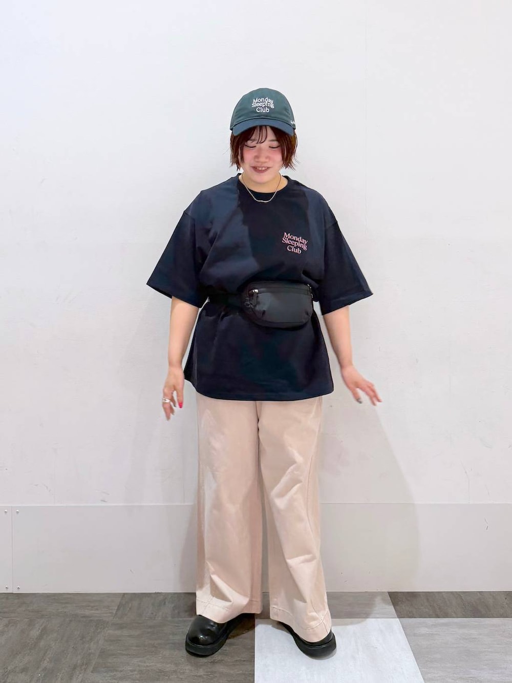 ピンク系のデニムパンツ、ブラック系のボディバッグ/ウエストポーチ、ブルー系のTシャツ/カットソーを着用したレディースの春コーディネートの3枚目の写真