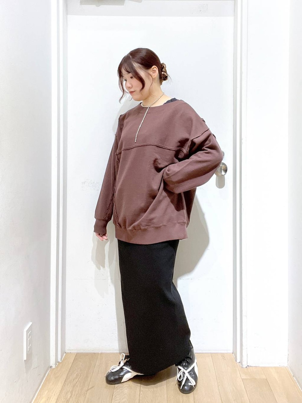 ブラック系のスカート、ブラウン系のスウェットを着用したレディースの秋コーディネートの2枚目の写真