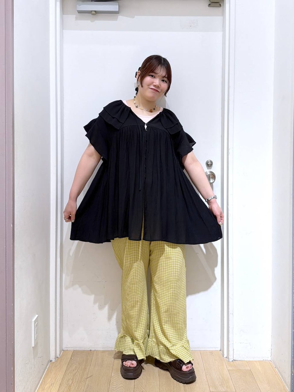 ブラック系のワンピース、ブラウン系のサンダル、イエロー系のその他パンツを着用したレディースの夏コーディネートの3枚目の写真