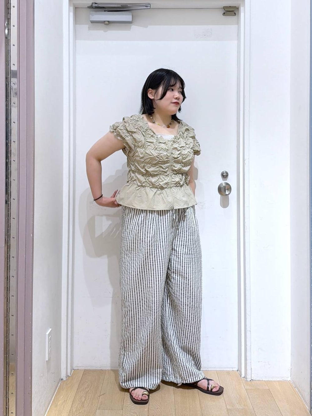 ベージュ系のシャツ/ブラウス、シルバー系のタンクトップ、ブラウン系のサンダルを着用したレディースの夏コーディネートの3枚目の写真