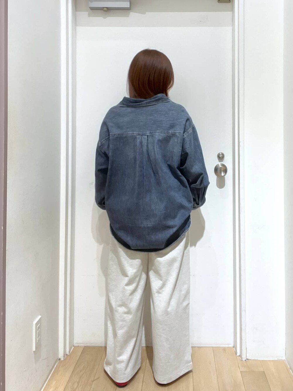 レッド系のパンプス、ブルー系のシャツ/ブラウス、グレー系のスウェットパンツを着用したレディースの冬コーディネートの3枚目の写真