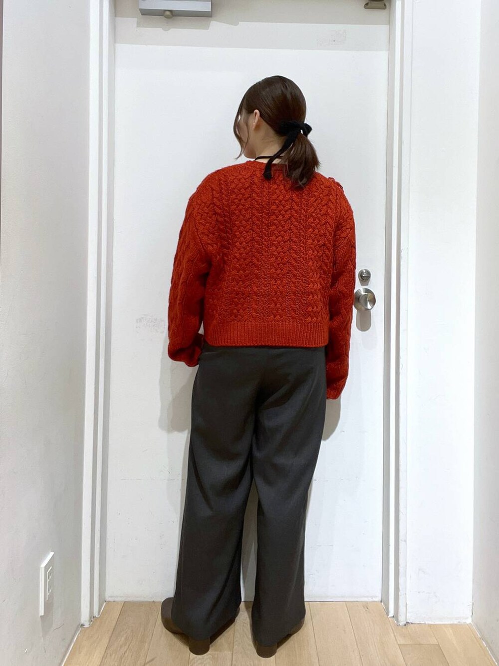 グレー系のその他パンツ、レッド系のポロシャツ、ブラウン系のブーツを着用したレディースの秋コーディネートの3枚目の写真