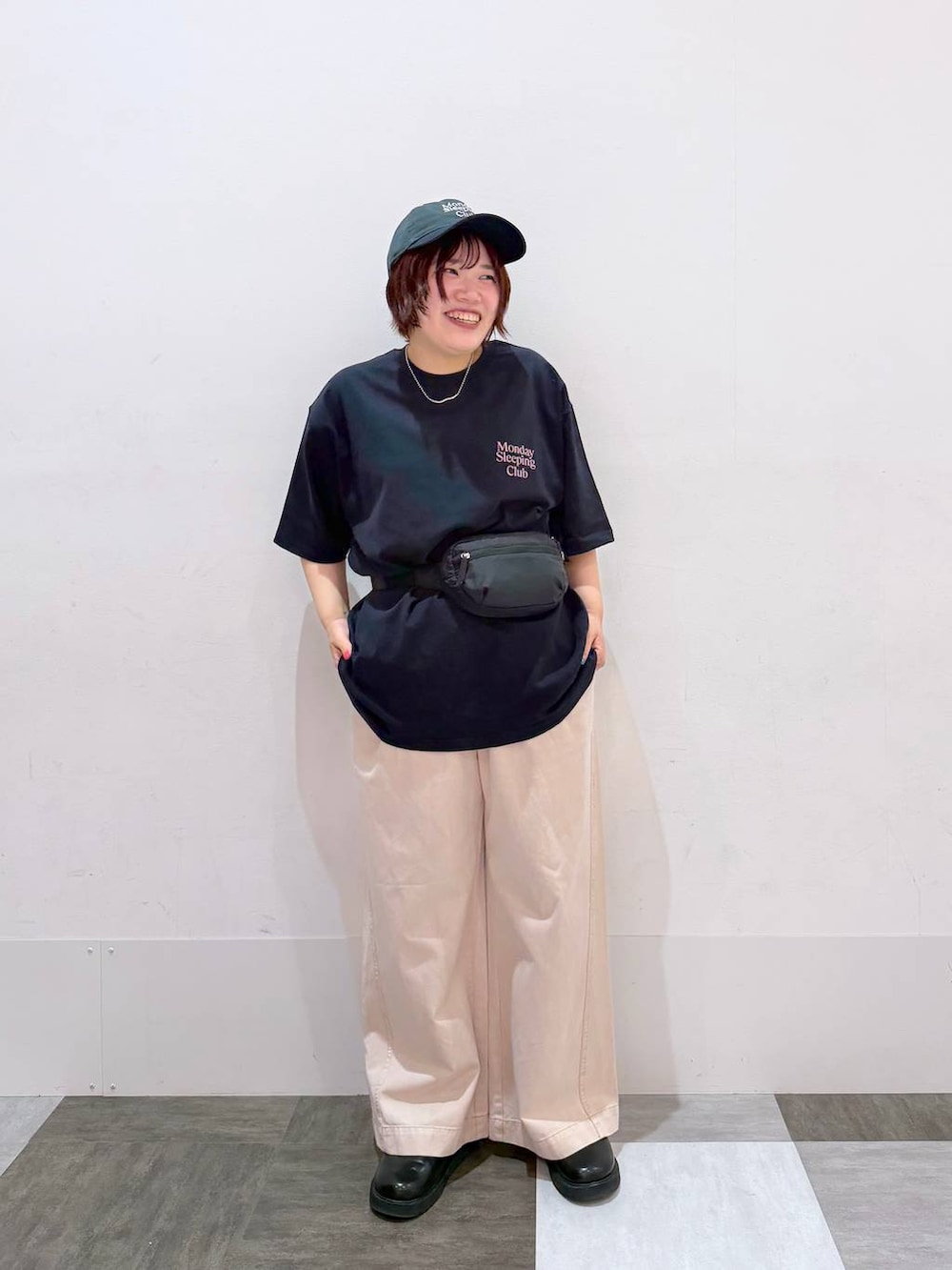 ピンク系のデニムパンツ、ブラック系のボディバッグ/ウエストポーチ、ブルー系のTシャツ/カットソーを着用したレディースの春コーディネートの2枚目の写真