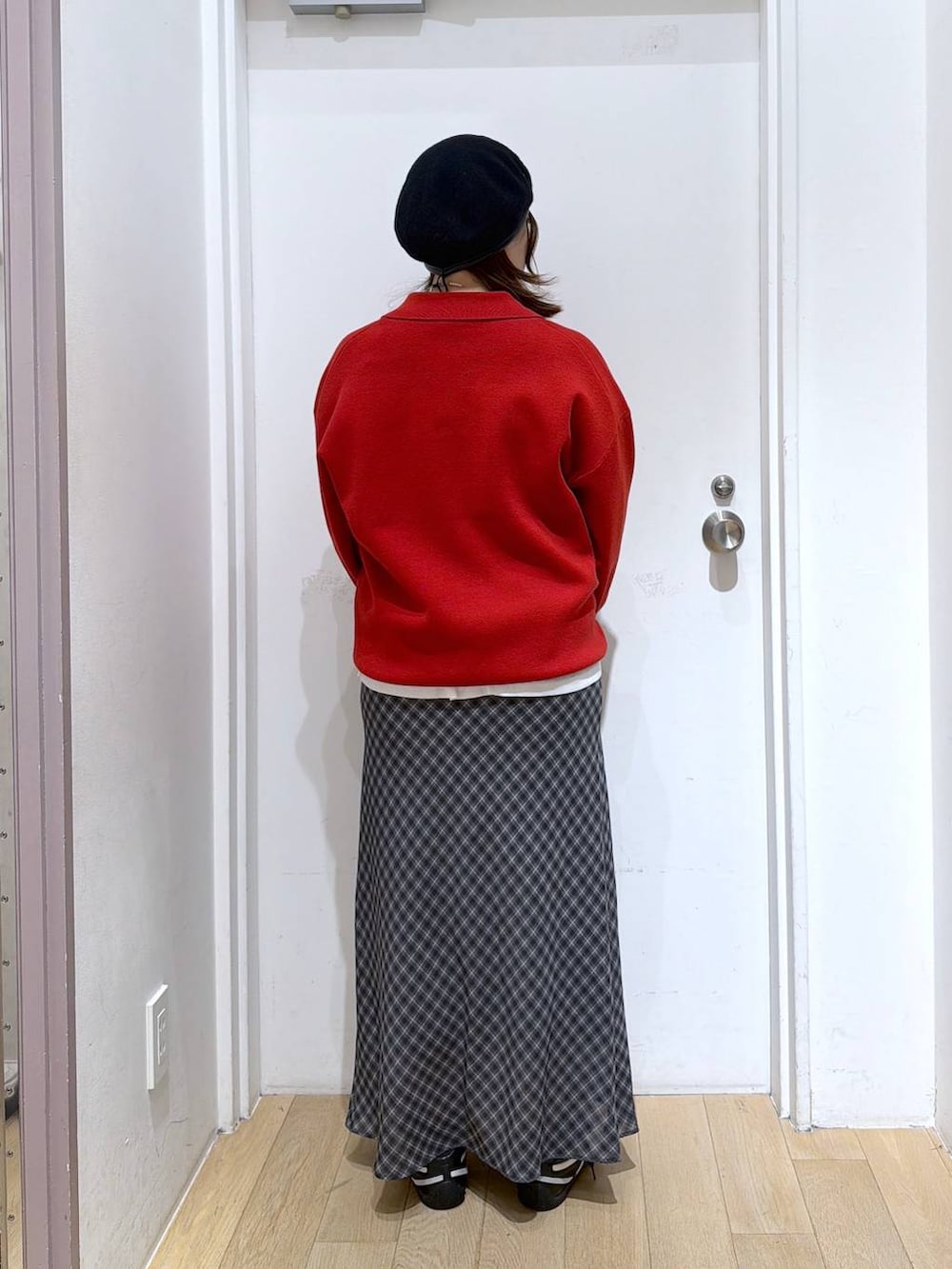 ホワイト系のTシャツ/カットソー、グレー系のスカート、レッド系のニット/セーターを着用したレディースの冬コーディネートの3枚目の写真