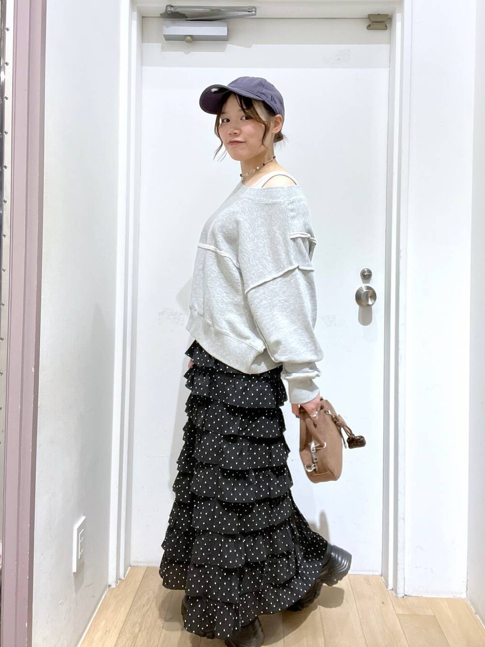 ブラック系のブーツ、グレー系のスウェット、ブラウン系のボストンバッグを着用したレディースの秋コーディネートの4枚目の写真