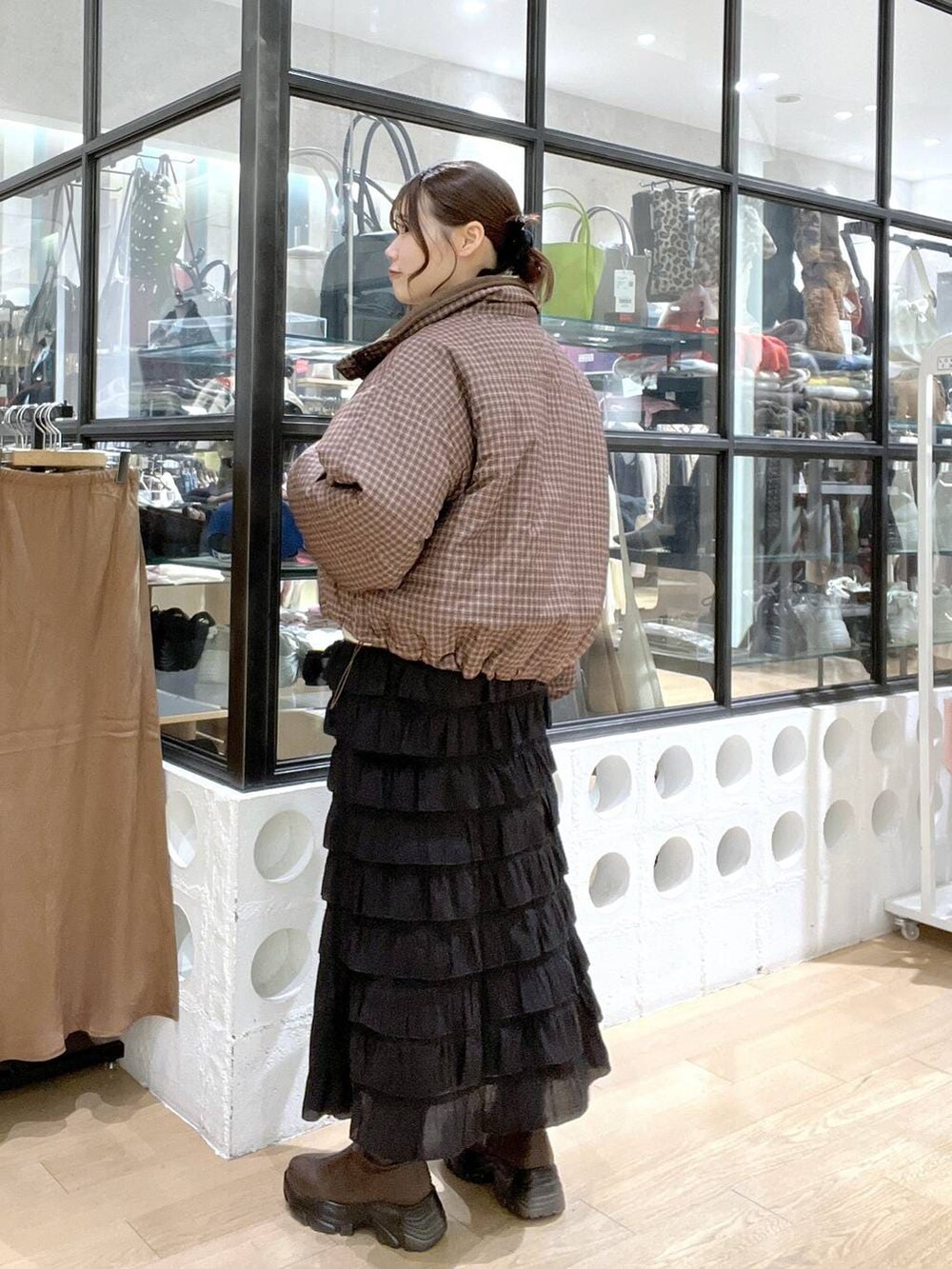 ブラウン系のブーツ、ブラック系のスカート、ホワイト系のニット/セーターを着用したレディースの冬コーディネートの3枚目の写真