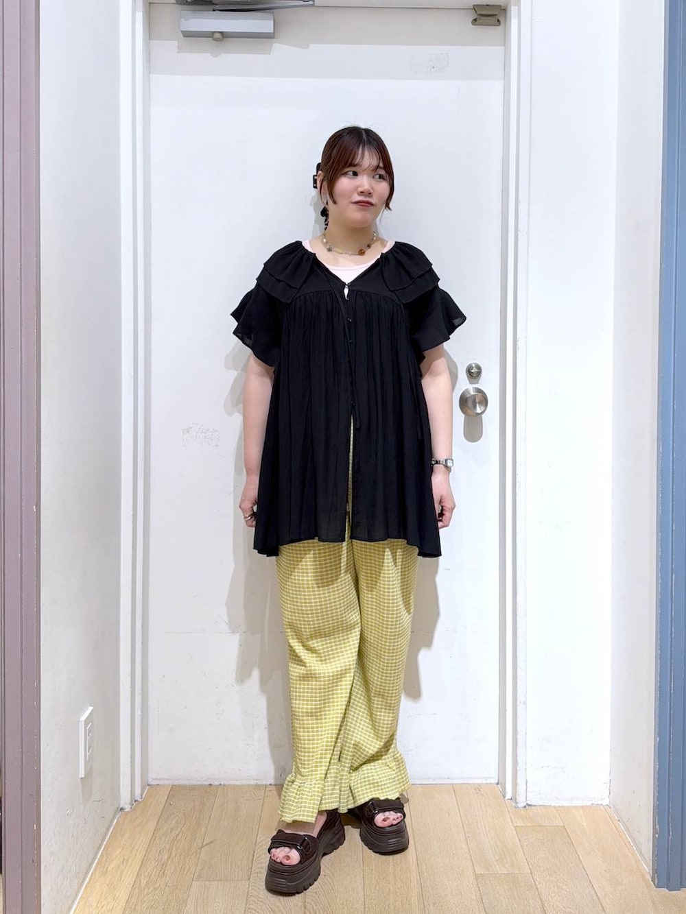 ブラック系のワンピース、ブラウン系のサンダル、イエロー系のその他パンツを着用したレディースの夏コーディネートの2枚目の写真
