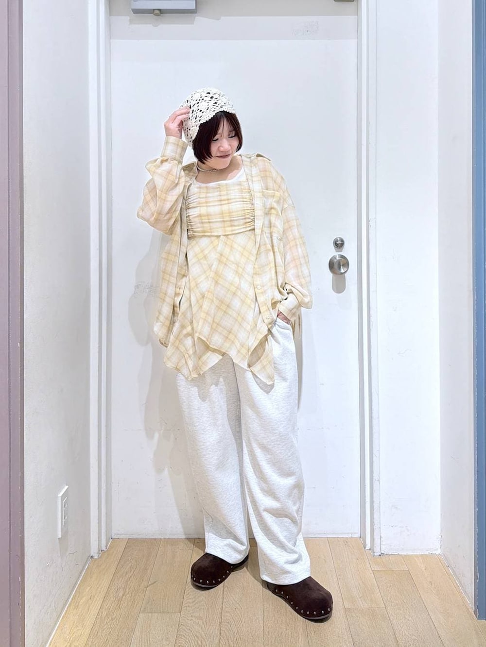 グレー系のスウェットパンツ、ブラウン系のサンダル、ホワイト系のタンクトップを着用したレディースの春コーディネートの2枚目の写真