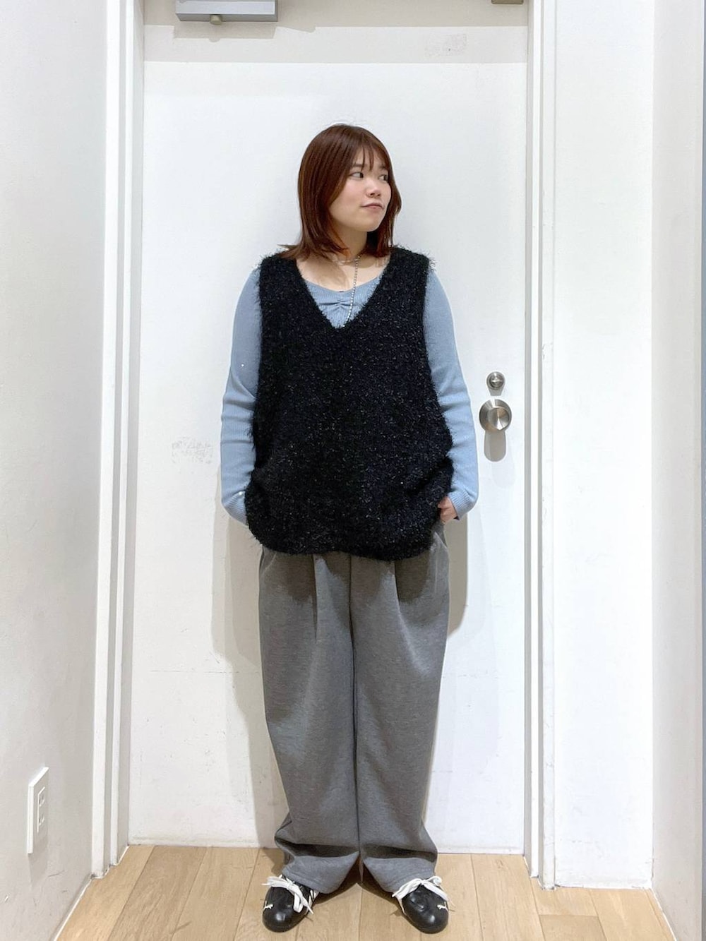 グレー系のスウェットパンツ、ベージュ系のショルダーバッグ、ブルー系のニット/セーターを着用したレディースの冬コーディネートの4枚目の写真