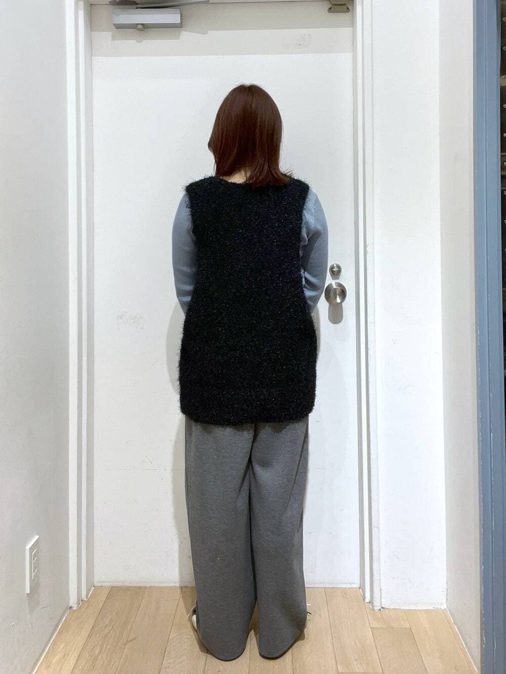 グレー系のスウェットパンツ、ベージュ系のショルダーバッグ、ブルー系のニット/セーターを着用したレディースの冬コーディネートの3枚目の写真