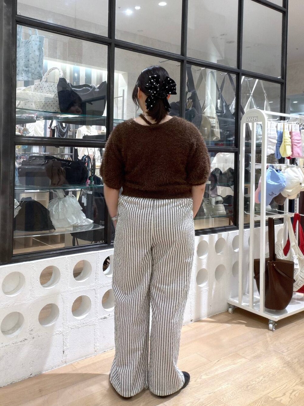 ブラック系のバレエシューズ、ブラウン系のカーディガン/ボレロ、ホワイト系のその他パンツを着用したレディースの夏コーディネートの4枚目の写真